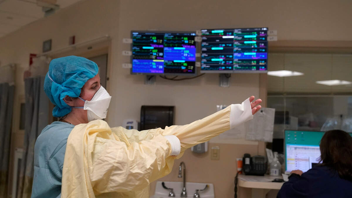 ARCHIVO - Una enfermera se viste con el equipo de protección antes de entrar en la habitación de un paciente en la Unidad de Cuidados Intensivos de COVID-19 en el Centro Médico Dartmouth-Hitchcock, en Lebanon, N.H., el 3 de enero de 2022. La variante ómicron ha provocado una oleada de nuevos casos de COVID-19 en Estados Unidos y muchos hospitales no sólo están desbordados de casos, sino que tienen una gran escasez de personal a causa de tantos empleados con COVID-19. (AP Photo/Steven Senne, Archivo)