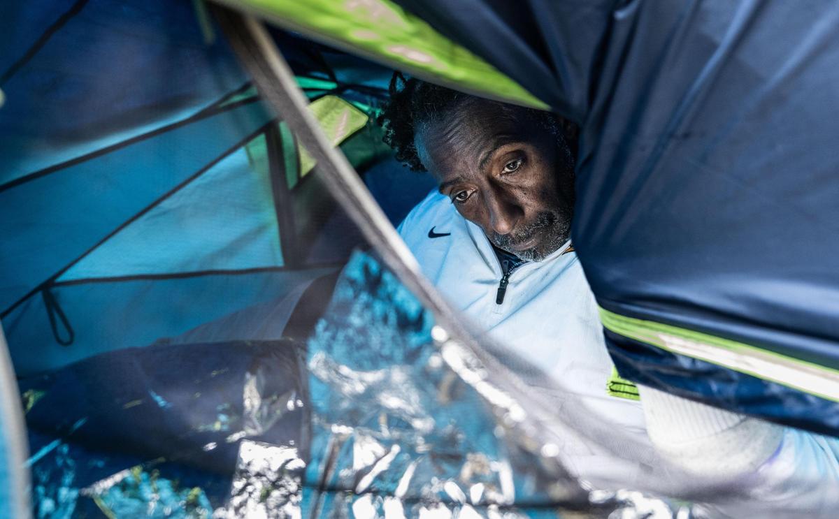 Ani Baker, 61, a Sacramento homeless man sits inside his tent at Cesar Chavez Plaza in downtown Sacramento on Thursday. Baker, who shares the tent with his partner, said that he doesn’t know where he will move after receiving a notification to leave to leave the area. Signs posted Wednesday indicate a movie will be filmed in the area of the park starting Saturday.