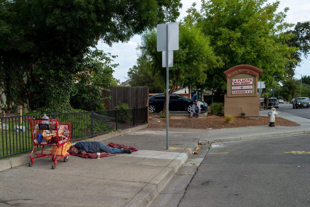 Mark Rippee, appears lifeless as he sleeps on a sidewalk in Vacaville on Aug. 1 when his sister Linda Privatte spotted him in the early morning. His shopping cart was filled with mostly garbage that she cleared out before giving him a hot breakfast of eggs and coffee with sugar.