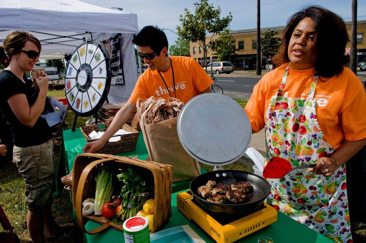 Michele Lites, right, a registered nutritionist from Kaiser served up free samples of turkey burgers that she made along with a recipe book on the first day of a new city-sponsored Farmers Market at Oak Park on Saturday, May 15, 2010.