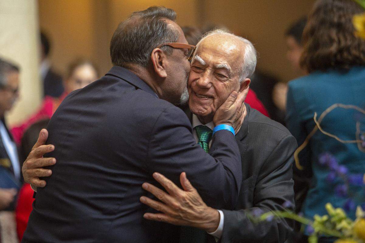 Angelo Tsakopoulos is kissed by Los Angeles City Councilmember Gil Cedillo, a Democrat who served in both houses of the the state Legislature, during the swearing in of Tsakopoulos’ daughter Eleni Kounalakis as lieutenant governor in 2019. The Tsakopoulos family has long been active in Democratic circles.