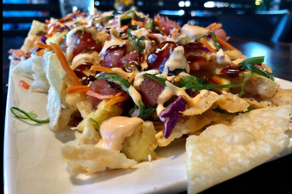 Goose Port’s spicy poke nacho platter includes tuna sashimi, pineapple and serrano chilis over a bed of wonton chips.