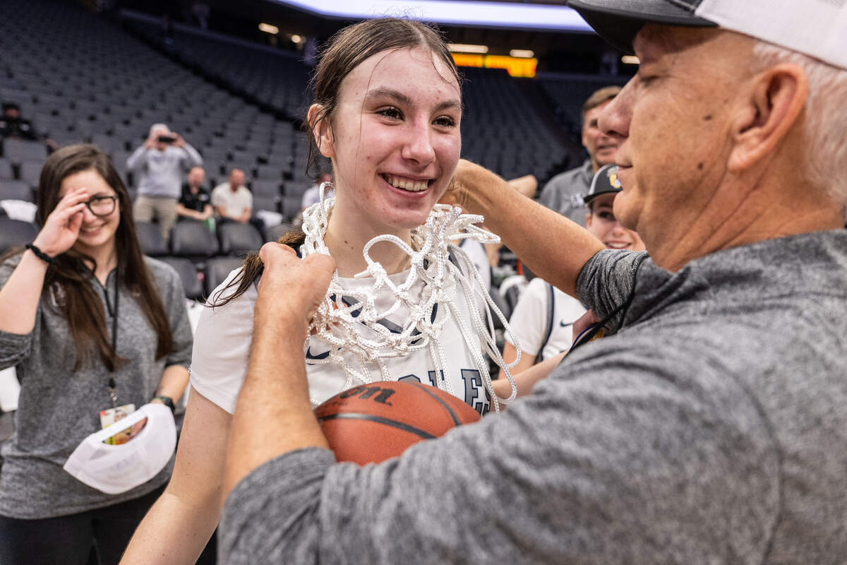 The Vista del Lago Eagles’ Ella Skrzyniarz (14) receives the championship net from coach Marty Benjamin after winning the CIF Sac-Joaquin Section Division III girls basketball section championship on Wednesday at Golden 1 Center.
