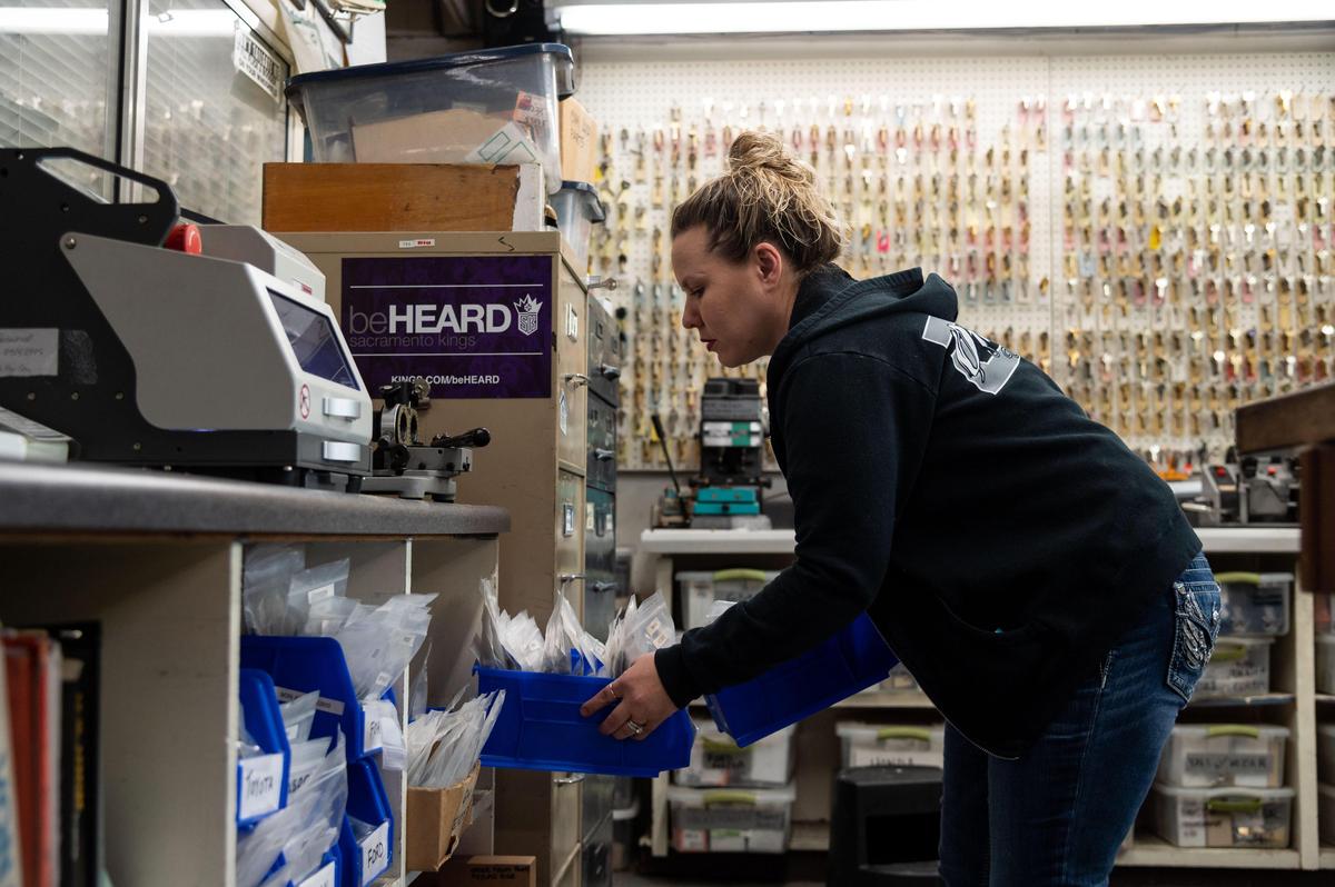 Elk Grove Lock & Safe employee Nicole Sanchez works with customers April 1, 2020, at the family business on Elk Grove Boulevard. Owner Ted Hoffmeister, who runs the business with wife Anita, said, “We’re invited into people’s houses all day long and people’s businesses so we’ve been really taking extra caution … wearing masks, wearing gloves … in between jobs they all disinfect their hands, that type of thing.” He added that their son, Geoffrey Hoffmeister, was currently out on a job. “We’re just doing the best we can to — while interacting with the public – doing the best we can to not spread anything.”