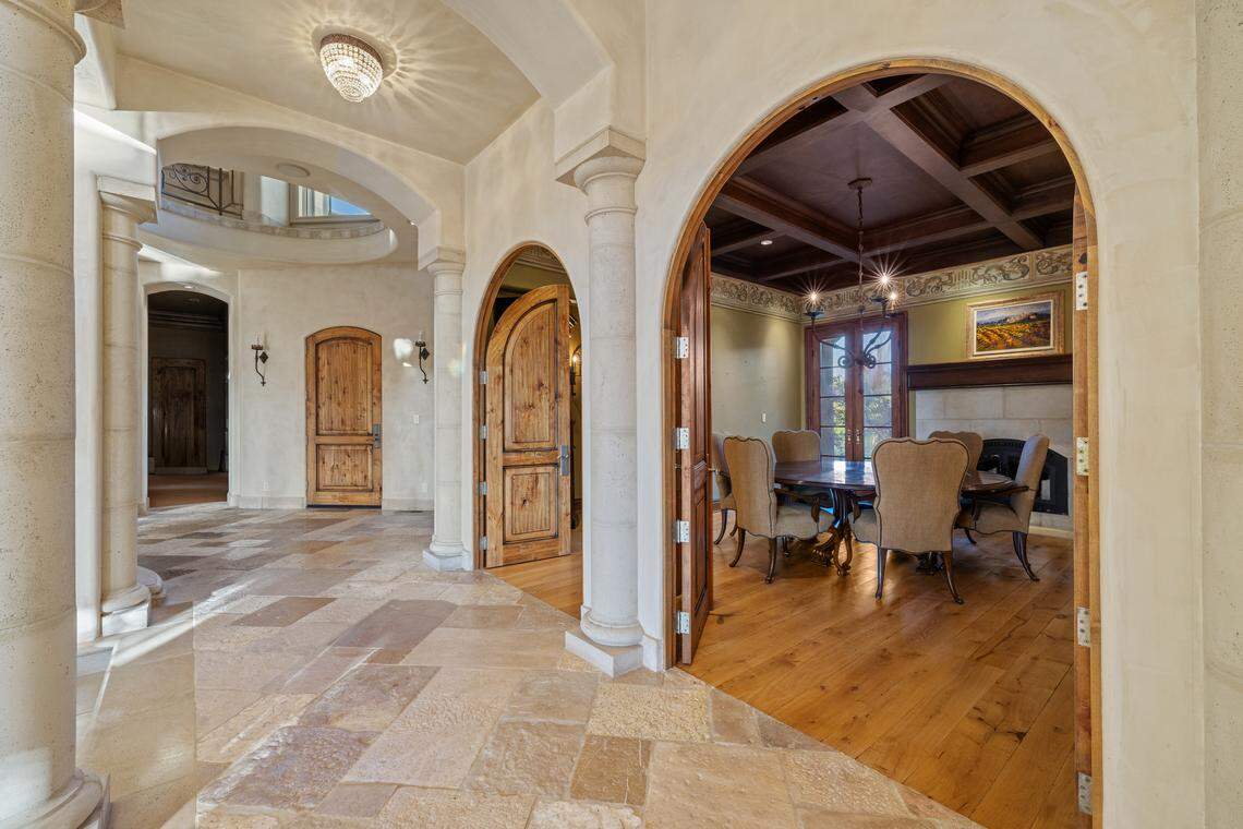 A soaring circular entry with 23-foot ceilings welcomes guests to the Tilton residence, where reclaimed French oak floors, custom ironwork, and a two-story fountain set the tone for Old World elegance. The four-bedroom, seven-bath home was designed by architect Tim Sheil and interior designer Paulette Trainor.