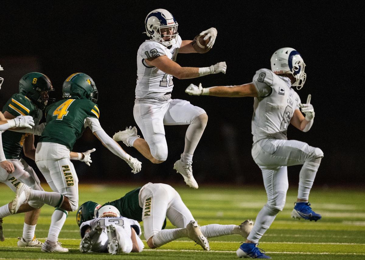 The Casa Roble Ram’s Connor Campbell (12) jumps over a teammate and a Placer High School defender on Friday in Auburn during the season opener for both teams.