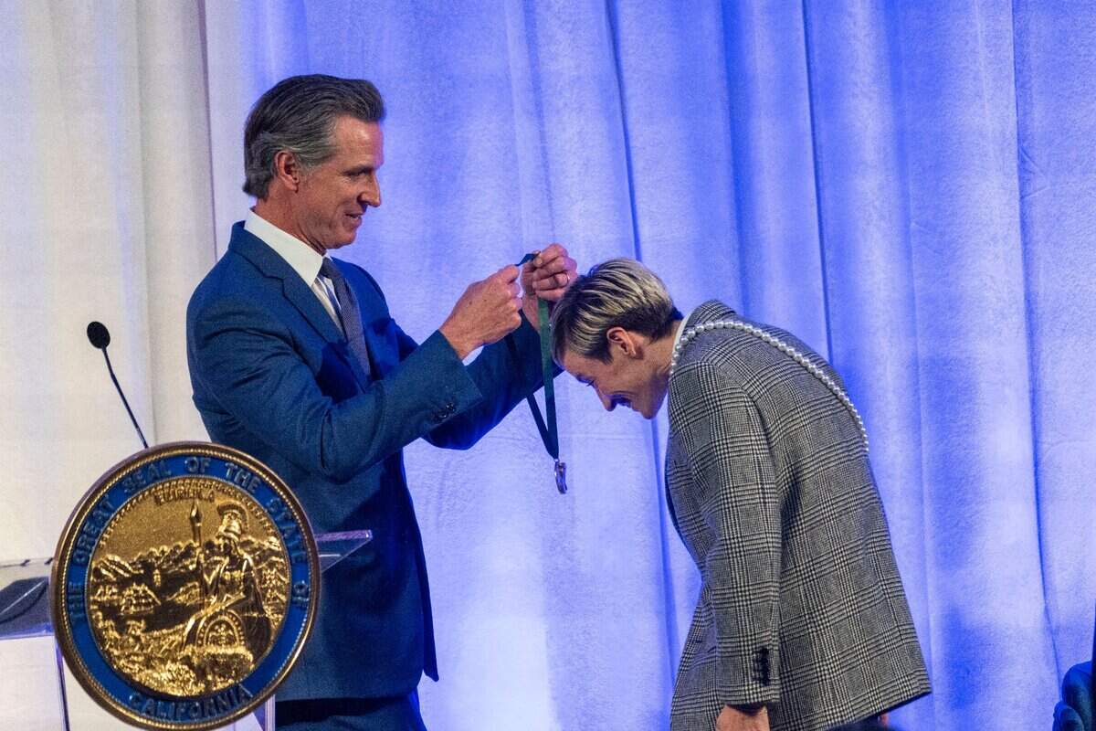 Soccer player Megan Rapinoe receives her medal from Gov. Gavin Newsom during the California Hall of Fame induction ceremony Tuesday, Dec. 13, 2022, in Sacramento.