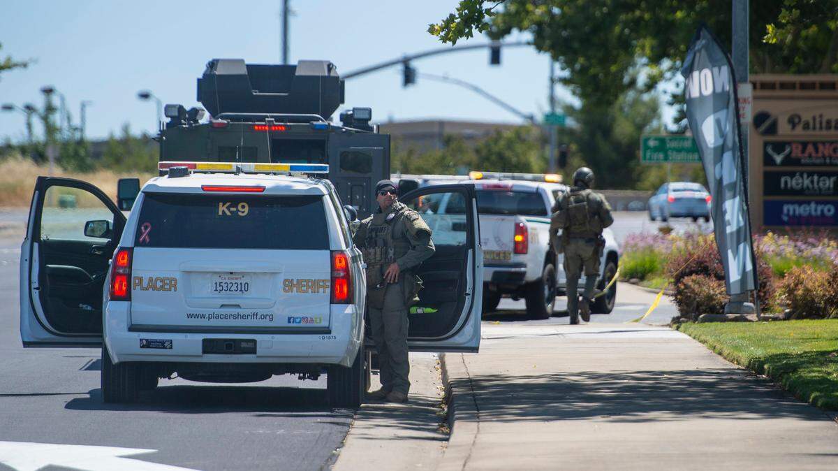 Placer County sheriff’s deputies wait on July 9 at the staging area for the manhunt for escaped Mahany Park murder suspect Eric James Abril, who escaped earlier in the morning from Roseville hospital.