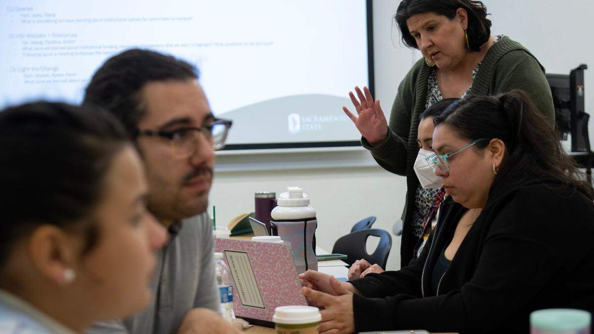 Associate Professor Amber Gonzalez, standing at right, works with students on Friday, April 14, 2023, in a research project to gauge student’s perception of Sacramento State’s designation as a Hispanic-Serving Institution. Some professors and students believe the university could do a better job supporting Latinos.