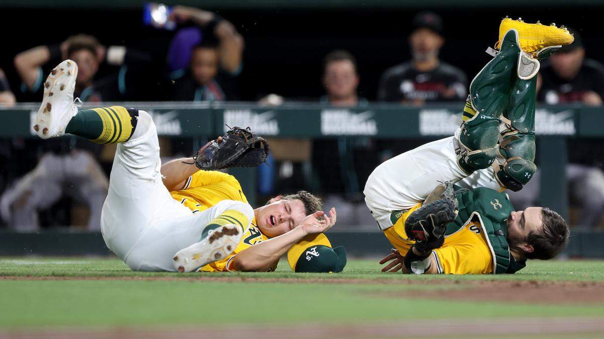 Athletics first baseman Nick Kurtz, left, and catcher Shea Langeliers collide while attempting to catch a foul ball against the Arizona Diamondbacks during the seventh inning Saturday at Sutter Health Park in West Sacramento.