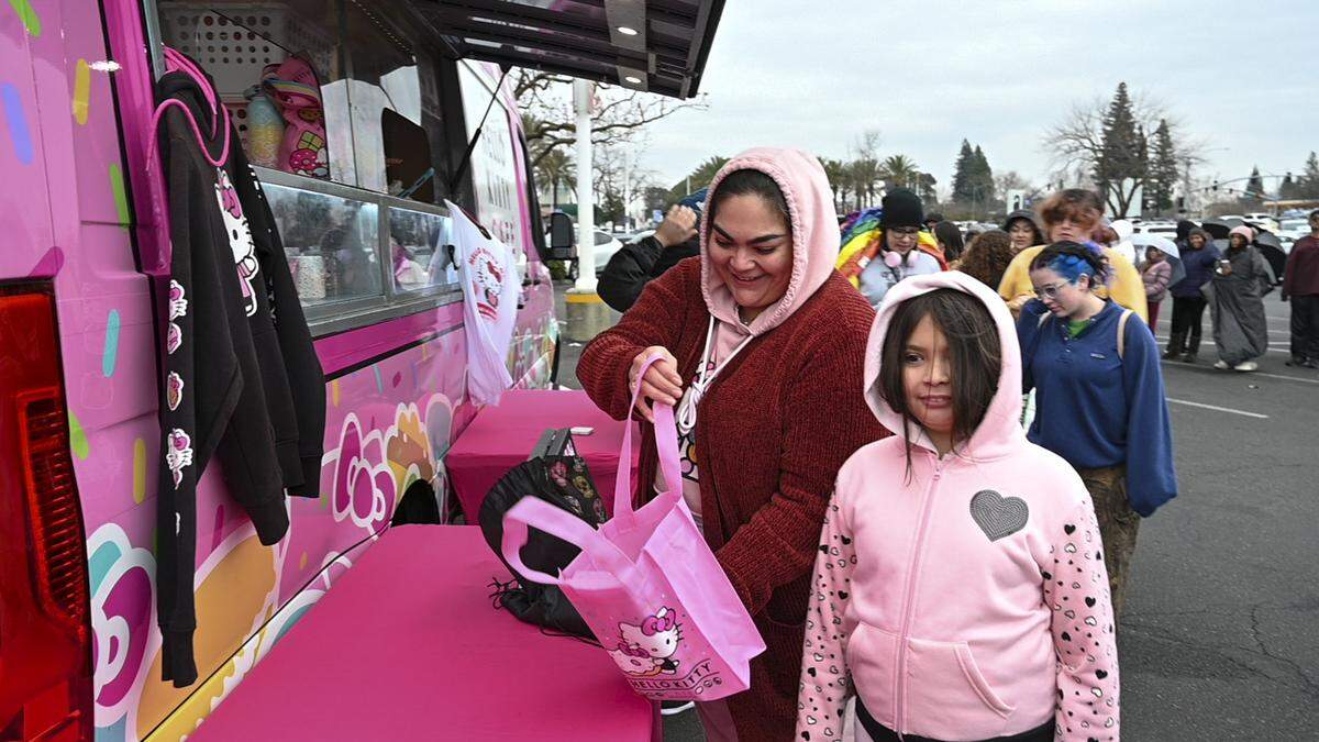 Cristina Martinez, left, and her daughter Charly Smith, 9, of Sacramento, buy merchandise at the Hello Kitty Cafe Truck parked at Arden Fair mall on Saturday.
