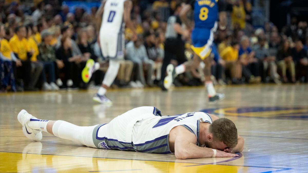 Sacramento Kings center Domantas Sabonis (10) lies on ground after being in the face by Kevon Looney on a jump ball during Game 6 of the first-round NBA playoff series at Chase Center on Friday. No foul was called.