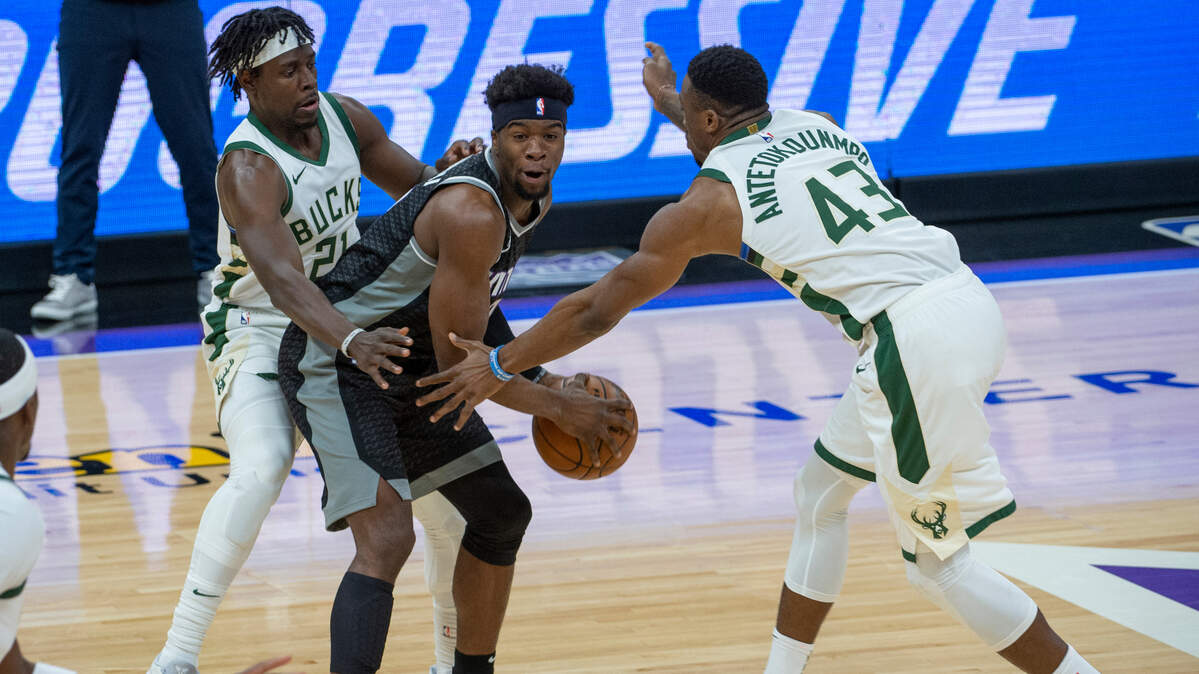 Milwaukee Bucks guard Jrue Holiday (21) and forward Thanasis Antetokounmpo (43) guard Sacramento Kings guard Terence Davis during the first quarter of an NBA basketball game in Sacramento, Calif., Saturday, April 3, 2021. (AP Photo/Randall Benton)