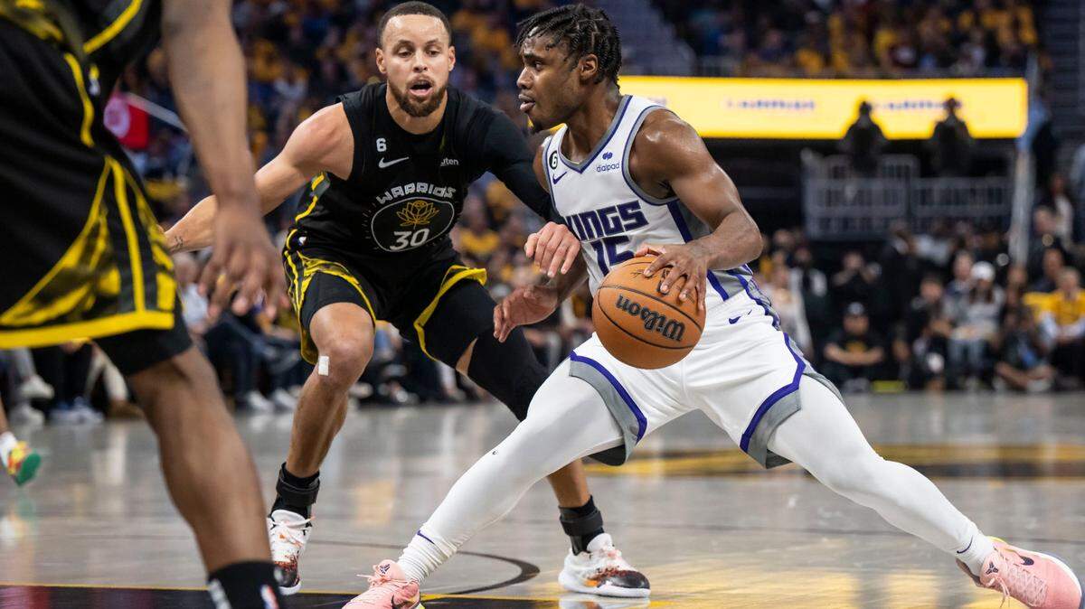Sacramento Kings guard Davion Mitchell (15) dribbles as Golden State Warriors guard Stephen Curry (30) defends during Game 3 of their playoff series in April.