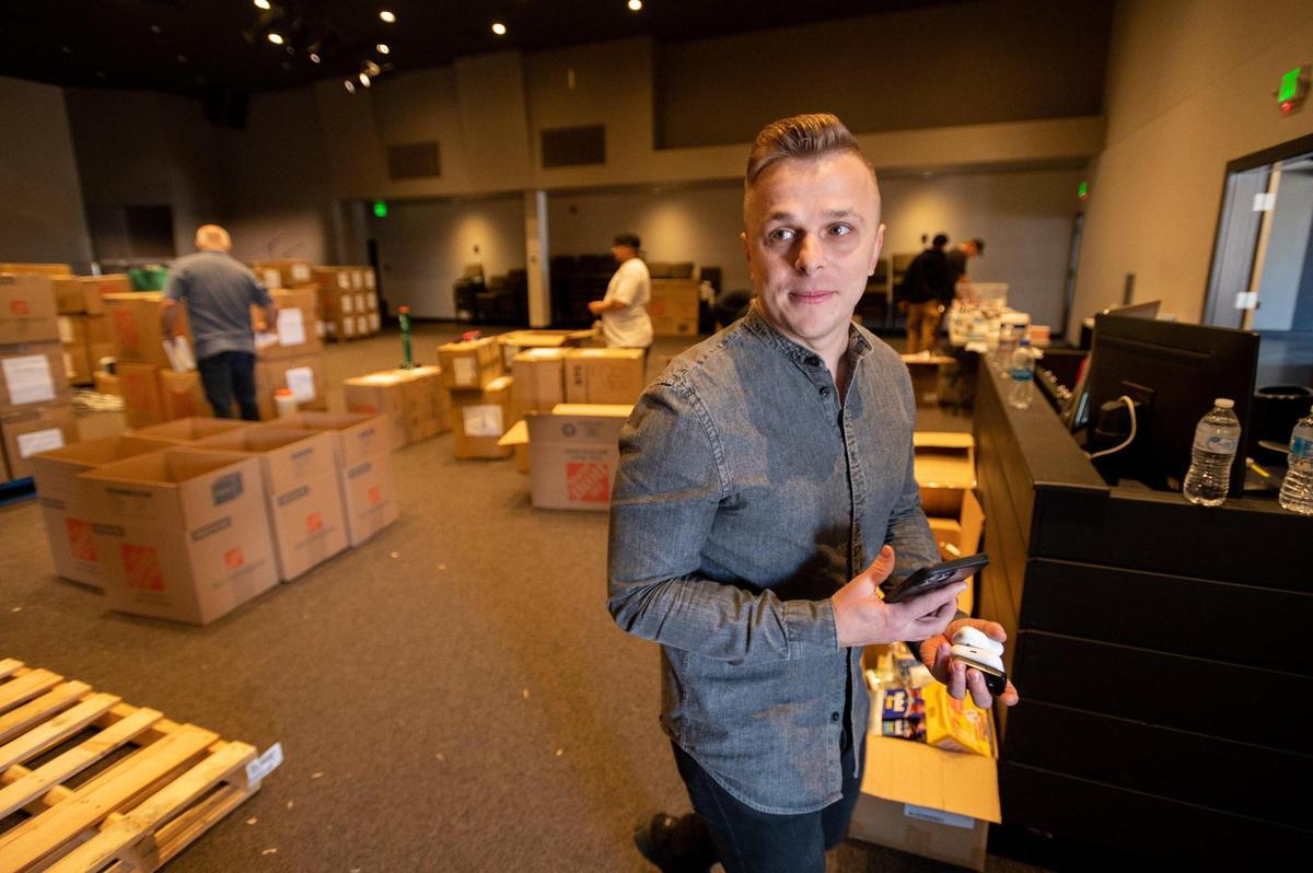 House of Bread Church Pastor Vlad Kotyakov keeps his phone close while coordinating relief efforts for Ukraine from his Orangevale church as volunteers sort and repackage donated medical items, clothing, and non-perishable food on March 22.