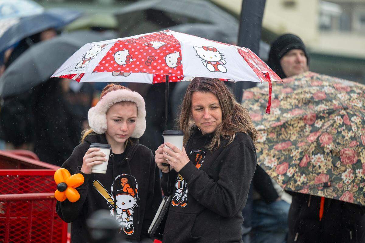 Yuba City residents Lexi Brisker, 13, and her mother Nichole try to stay warm with a hot drink in the rain and wind while in an autograph line during the San Francisco Giants Fanfest on Saturday, Feb. 1, 2025 at Sutter Health Park.