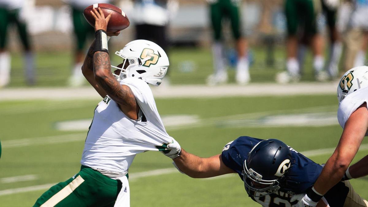 Cal Poly’s Jalen Hamler is dragged down by UC Davis’ Luka Nixon for a sack in the second quarter of the football game Saturday, March 20, 2021, in Davis.