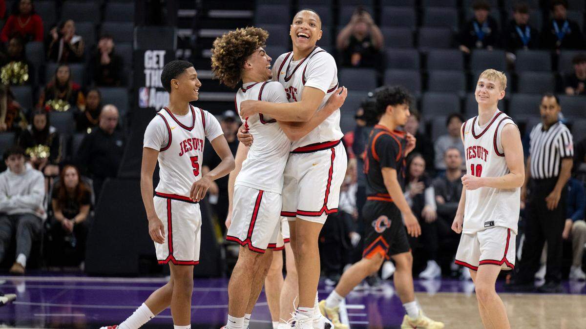The Jesuit Marauders’ Amaury McKinney (32) celebrates with teammate Brandon Williams (1) following the victory in the CIF State Division II boys basketball final against the Chatsworth Chancellors on Saturday at Golden 1 Center in Sacramento.