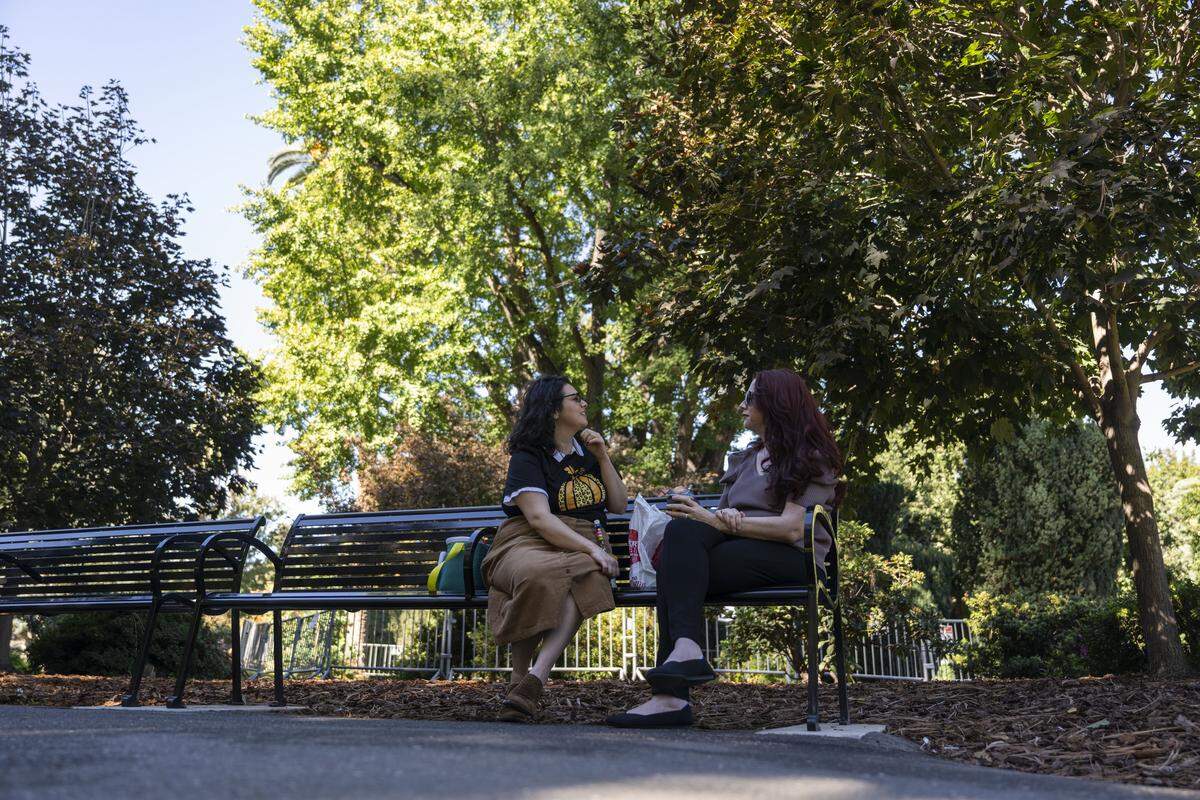 Co-workers take their lunch break near a fenced-off ginkgo tree at the California  Capitol on Monday. The tree’s fruit, known for its foul odor and slippery texture, led officials to restrict access to the surrounding walkway.