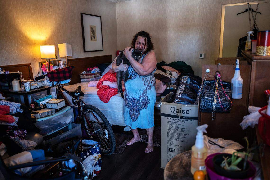Project Roomkey participant Tami McGraw, 59, hugs her cat Smokey inside her room at the Vagabond Inn motel in Sacramento on Wednesday. “If this program gets shut down a lot of people like me and worse than me are going to be out in the streets and dying. We got people in hospice that, if they don’t have a place to live, hospice does nothing for them,” said McGraw.