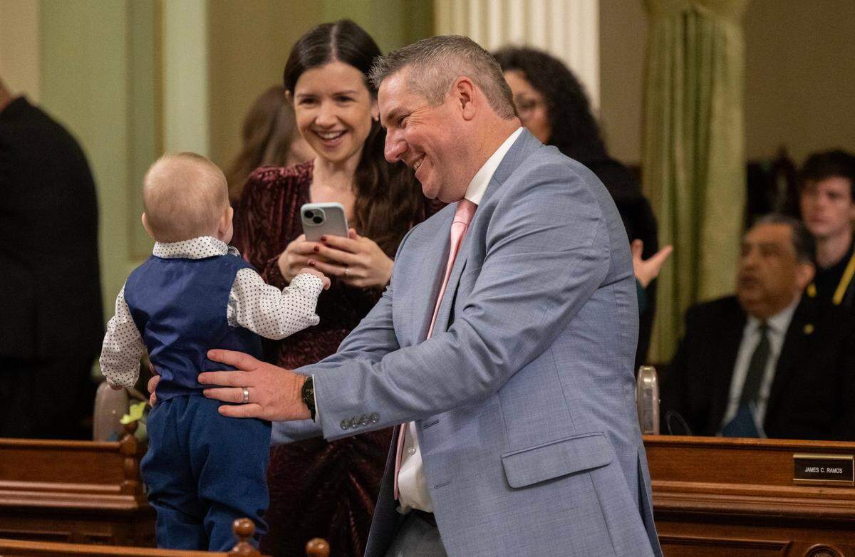 Assemblymember Chris Rogers, D-Santa Rosa, holds son Ellis, 6 months, as partner Sarah Bellak takes a photograph at the state Capitol during the Assembly’s first meeting of the new legislative session on Monday.