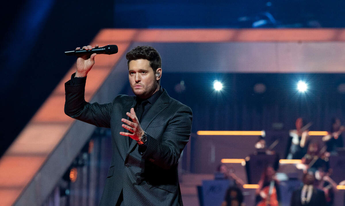 Michael Bublé hold up the microphone as he finishes a song while performing on his Higher Tour at Golden 1 Center in Sacramento on Saturday.