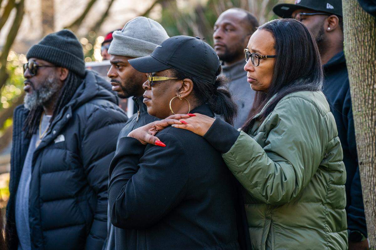 Tashante McCoy-McGaskey, center, whose brother died from gun violence in 2012, listens with Leia Schenk, right, founder of EMPACT, and Patrick Peterson, left, father of 14-year-old Amari, who was killed in the Nov. 29 mass shooting, during a press conference in Sacramento at Capitol Park, held by survivors of crime from Stockton, calling for investments in crime and harm prevention on Tuesday.
