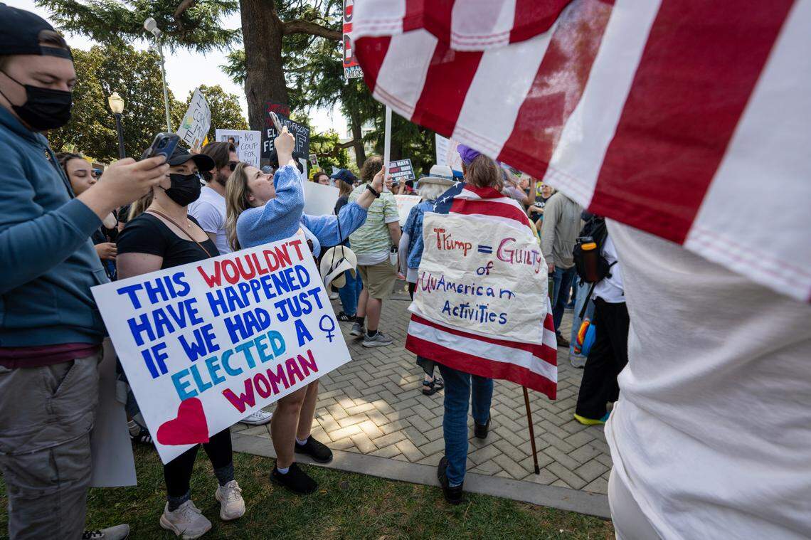 Kristina Lee photographs political signs during the 50501 protest against the Trump administration at the state Capitol on Saturday, April 4, 2025.