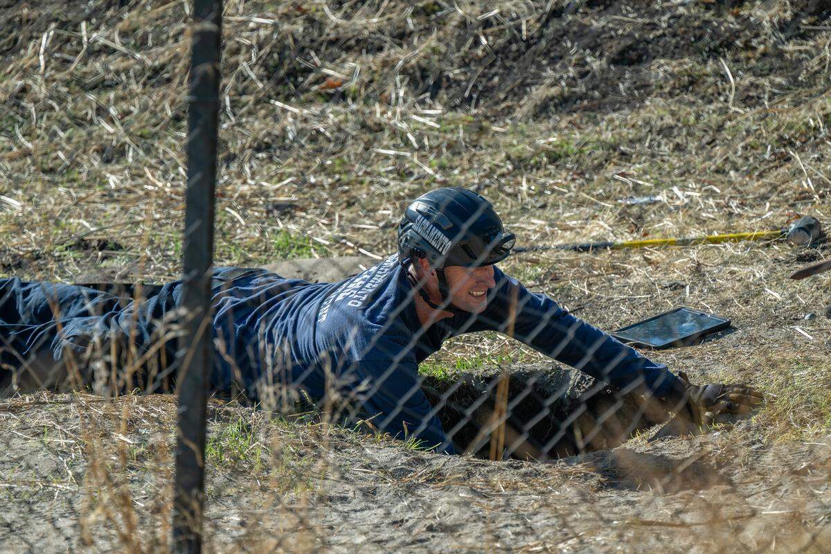 A Sacramento firefighter checks a hole on the opposite side of a fence where workers were searching a partially collapsed tunnel on Friday.