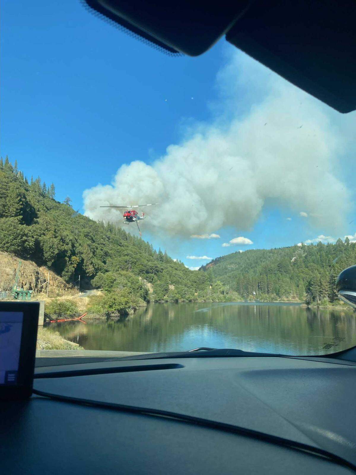 A helicopter is seen dousing flames at the Dutch Fire along Dutch Flat Forebay’s dam in Nevada County.