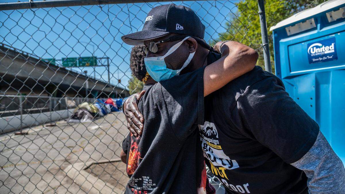 Ernie King, of the Poor Peoples Campaign, hugs Shari Spikes, 59, as she moves into the W-X “Safe Ground homeless encampment on Wednesday, April 7, 2021. The lot has two distinct spaces: One for tent camping, the other for vehicle parking. A third just opened near Miller Park for vehicles only.