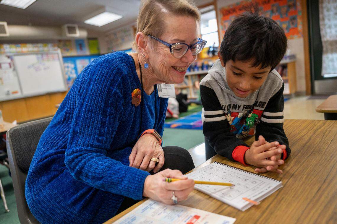 Retired teacher Lysa Sassman, who volunteers with Sight Word Busters, helps six-year-old Julian practice his letters as a prelude to sight word work Nov. 13 at Sierra Hills School in Meadow Vista.