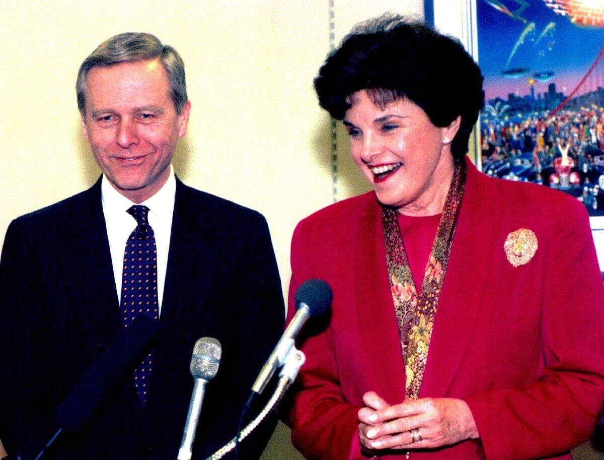 As California Gov. Pete Wilson stands at her side, U.S. Sen. Dianne Feinstein speaks to members of the media in her Capitol Hill office. It was the first meeting between the two since Wilson defeated Feinstein in the 1990 gubernatorial race. Wilson was in town for the National Governor’s Association winter meeting and to lobby for federal aid for California’s immigrant population.