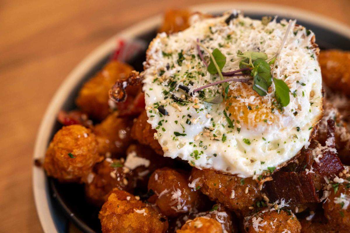 The Sunrise Poutine is available at Sunny Side Breakfast in Sacramento on Tuesday. The dish features steaming hot tater tots with bacon and a fried egg.