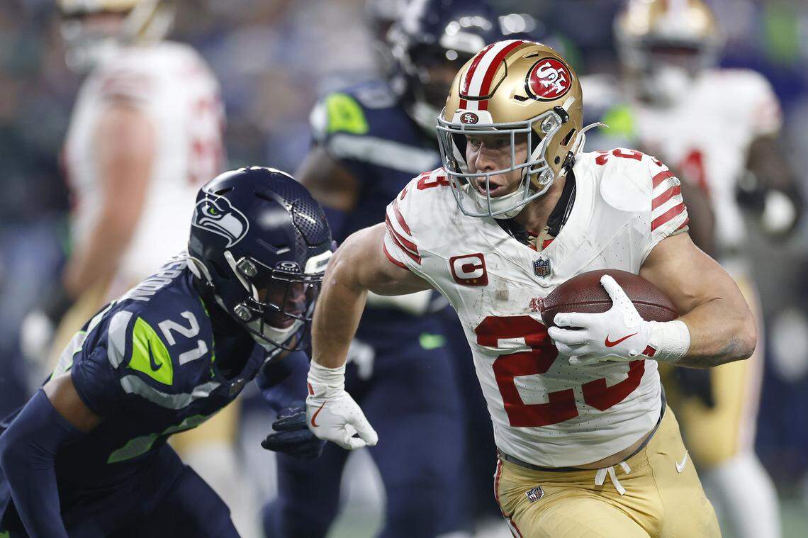 SEATTLE, WASHINGTON - JANUARY 17: Christian McCaffrey #23 of the San Francisco 49ers runs the ball against Devon Witherspoon #21 of the Seattle Seahawks during the second quarter in the NFC Divisional Playoff game at Lumen Field on January 17, 2026 in Seattle, Washington. (Photo by Harry How/Getty Images)