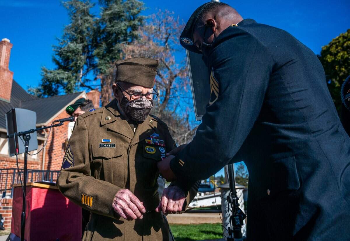 Staff Sgt. Clifton Pennywellbell pins a Bronze Star Medal and Purple Heart on Marvin D. Cornett at a ceremony in Auburn on Monday. Cornett, a World War II paratrooper in the 82nd Airborne Division, was injured by mortar fire after storming Anzio Beach in Italy in January 1944.