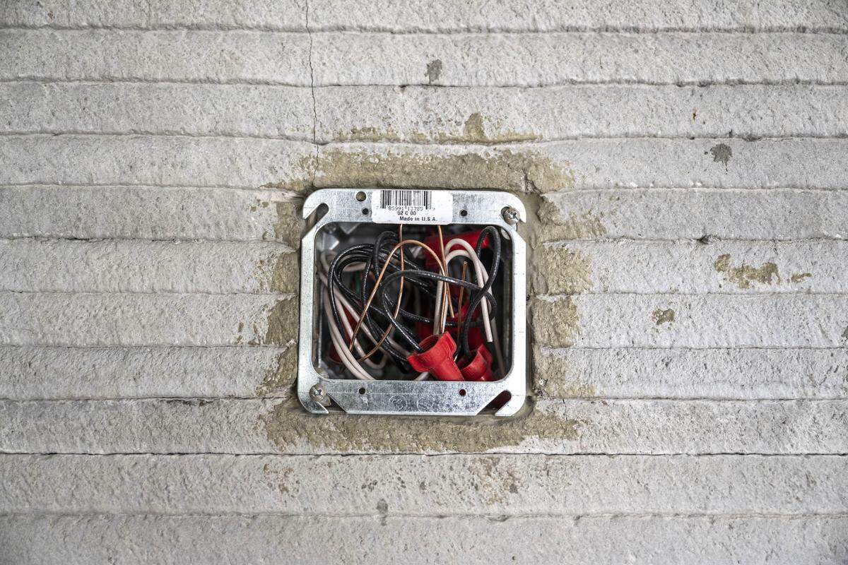 An electrical outlet at the first 3D-printed home in Yuba County. The concrete extruder fills the concrete around the electric box.