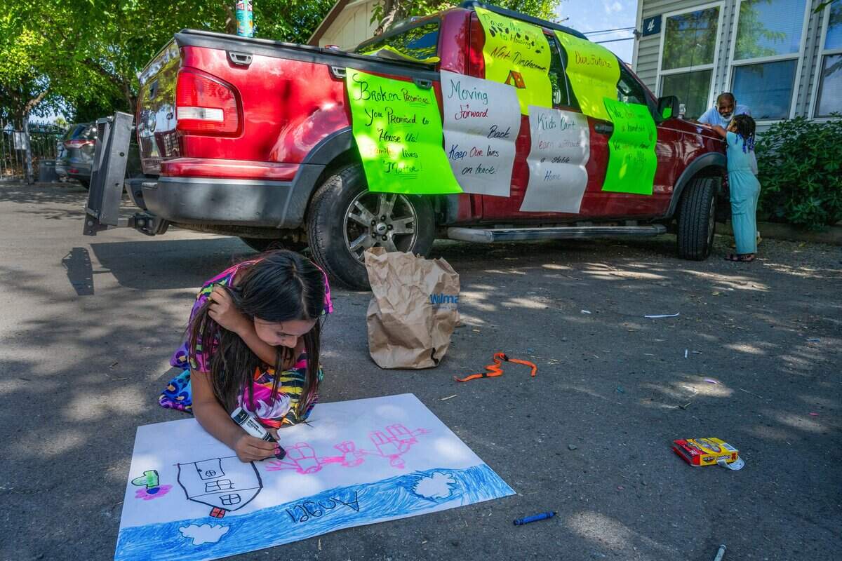 Angel Guevara, 9, begins drawing her dog, Bean, into a family picture before a press conference where four families are fighting to remain in their cottages at Arden Acres on Friday, June 5, 2026, in Sacramento. A recent change to the city of Sacramento’s motel shelter program left Angel, her mother and three siblings with nowhere to go.