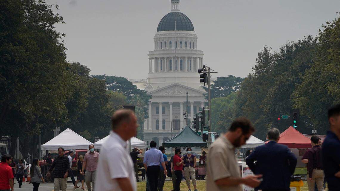 Smoke from area wildfires covers a farmers market and the California Capitol in Sacramento, Calif., Wednesday, July 28, 2021. (AP Photo/Rich Pedroncelli))