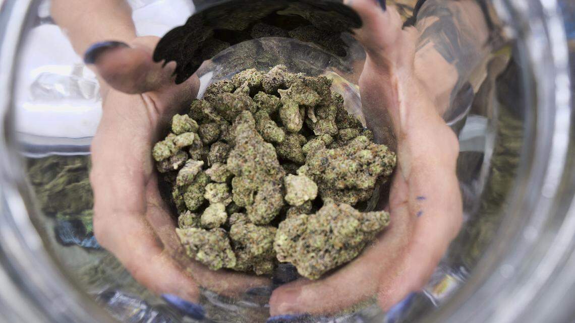 A bud tender displays a jar of cannabis at the High Times 420 SoCal Cannabis Cup in San Bernardino in this 2018 file photo.