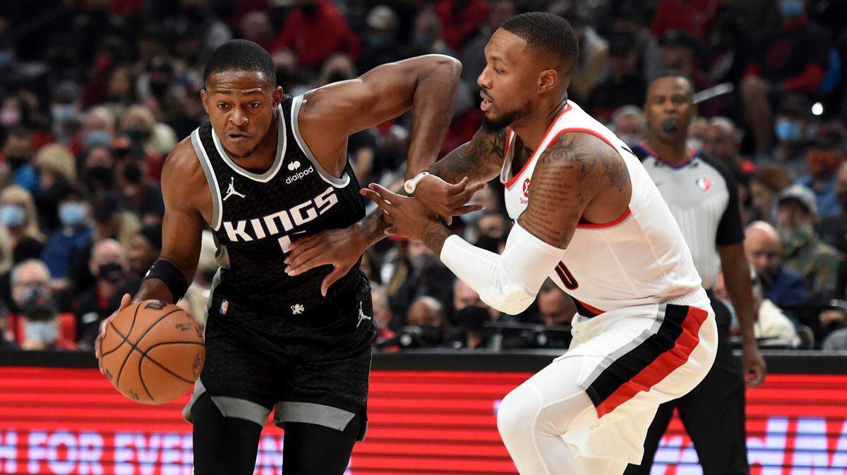 Sacramento Kings guard De’Aaron Fox, left, tries to get past Portland Trail Blazers guard Damian Lillard during the first half of an NBA basketball game in Portland, Ore., Wednesday, Oct. 20, 2021. (AP Photo/Steve Dykes)