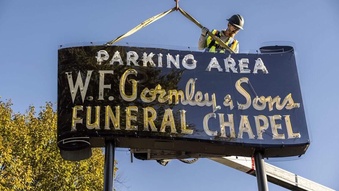 Workers install vintage W.F. Gormley & Sons neon sign at new Sacramento location