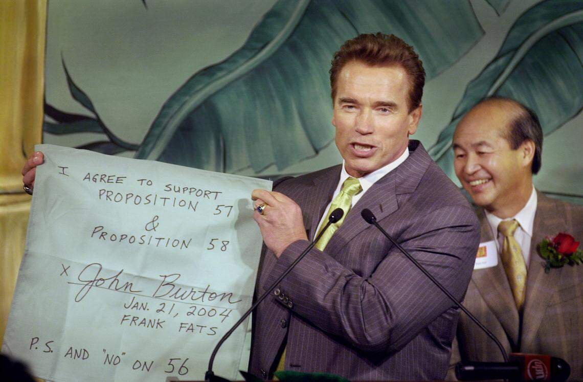Former Gov. Arnold Schwarzenegger holds up a mock “napkin deal” between him and California Sen. John Burton during Chinese New Year celebrations at Frank Fat’s in downtown Sacramento Wednesday, January 21, 2004. The downtown eating establishment is known for Capitol lawmakers doing deals drafted on Frank Fat’s cocktail napkins.