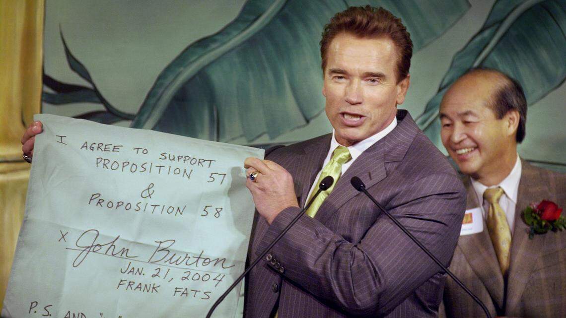 Former Gov. Arnold Schwarzenegger holds up a mock “napkin deal” between him and California Sen. John Burton during Chinese New Year celebrations at Frank Fat’s in downtown Sacramento Wednesday, January 21, 2004. The downtown eating establishment is known for Capitol lawmakers doing deals drafted on Frank Fat’s cocktail napkins.