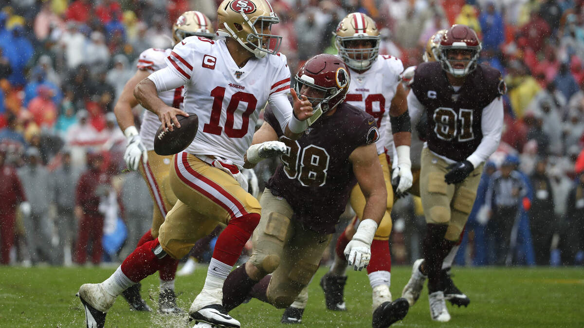 San Francisco 49ers quarterback Jimmy Garoppolo (10) looks for a receiver as he is pressured by Washington Redskins defensive end Matthew Ioannidis in the first half of an NFL football game, Sunday, Oct. 20, 2019, in Landover, Md. (AP Photo/Alex Brandon)