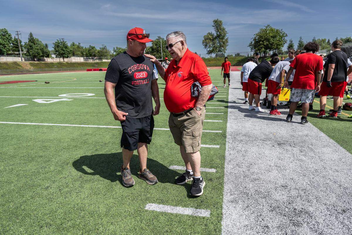 Cordova High School football coach JP Dolliver, left, talks with former coach Max Miller during spring training on Monday, May 20, 2024.