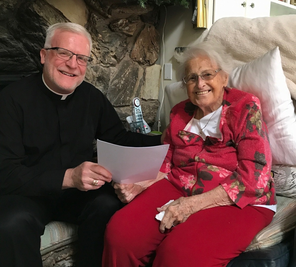 Agnes Anderson hands over the gift deed for her Wixford Way home behind Jesuit High School in Carmichael to Jesuit President John McGarry. Anderson wanted the school to use the home as a retreat and living and meeting area for Jesuit, but the school is suing to sell it.