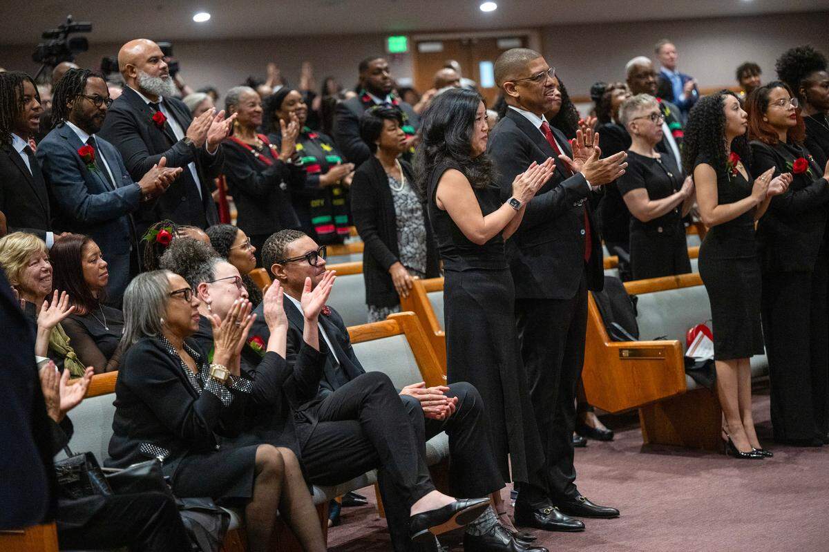 Kevin Johnson, the former mayor of Sacramento, and his wife Michelle Rhee applaud during the eulogy for his mother Georgia West, the driving force behind Underground Books in Oak Park, at her celebration of life memorial service at Saint Paul Church of Sacramento on Thursday, Jan. 23, 2024. The Rev. Claybon Lea Jr. gave the eulogy.