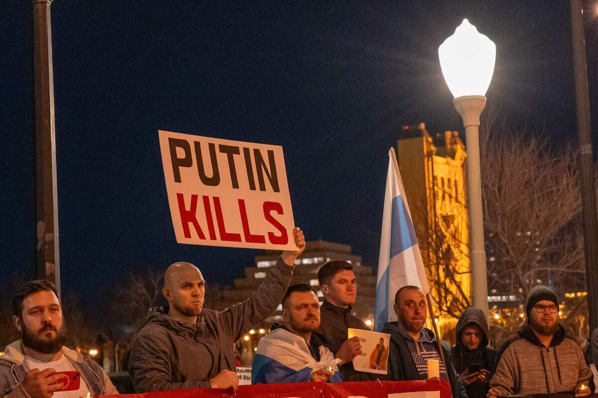 A demonstrator&nbsp;holds a sign that reads “Putin kills” during a candlelight vigil near the Tower Bridge in Sacramento on Tuesday to mourn the loss of Alexei Navalny, the Russian opposition leader who died in Arctic penal colony earlier this month.&nbsp;