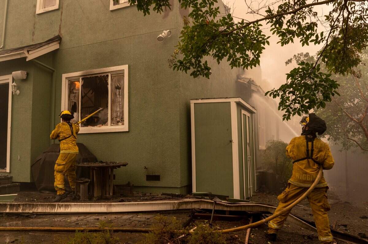 South San Francisco Department firefighters Gale Dietrich, left, and Joe Higgins work to put out the flames in a home on Mountain Hawk Drive in Santa Rosa burned by the Glass Fire on Monday, Sept. 28, 2020.